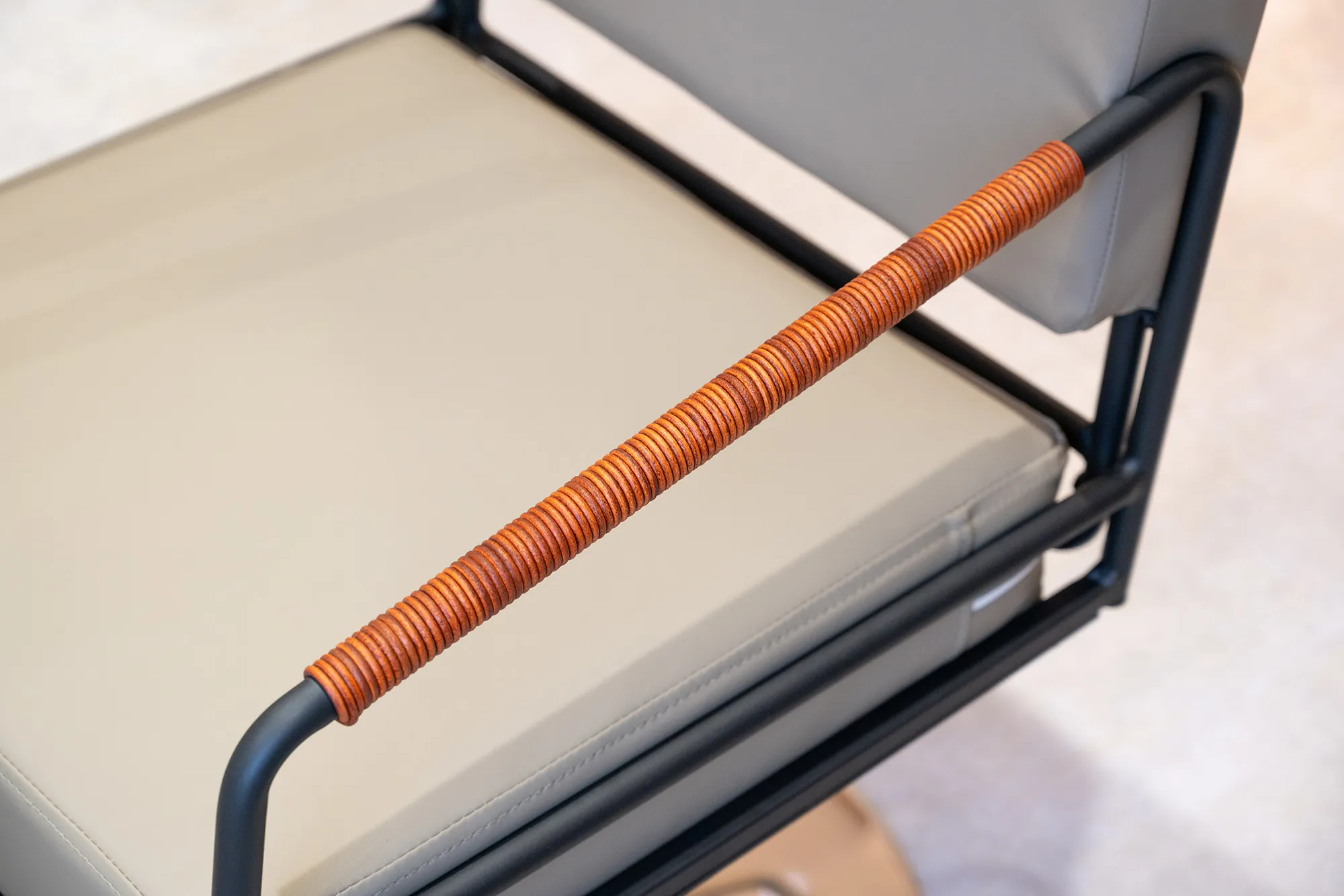 ブラウンのレザーが巻かれた、スタイリッシュなカットチェアの肘掛けのアップ。